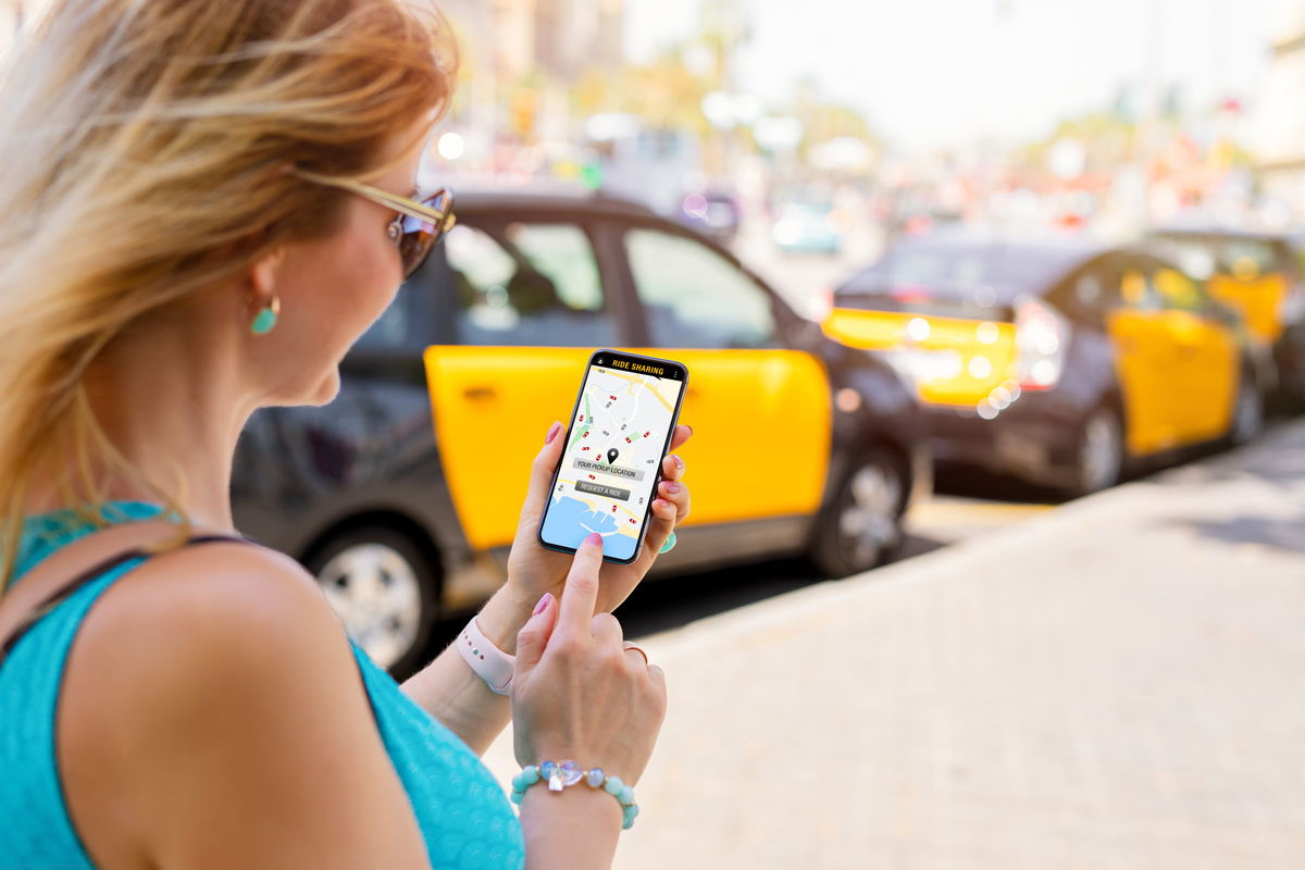 Woman using ride sharing app on mobile phone